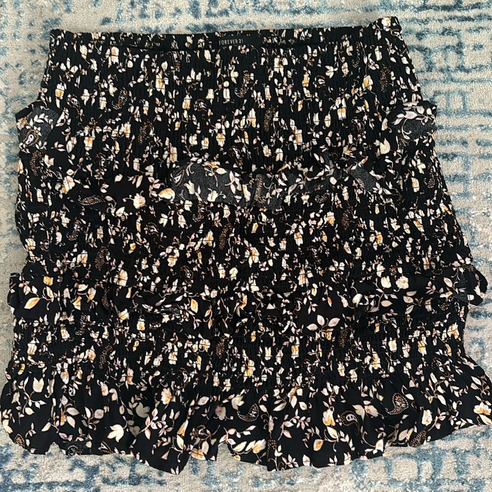 Floral tiered skirt, stretchy material. I would definitely call it a mini skirt